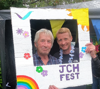 Image of 2 men smiling holding the JCH fest photo frame.